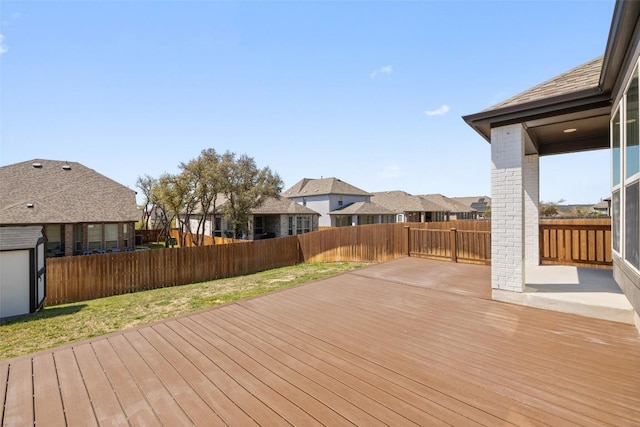 wooden terrace with a lawn and fence