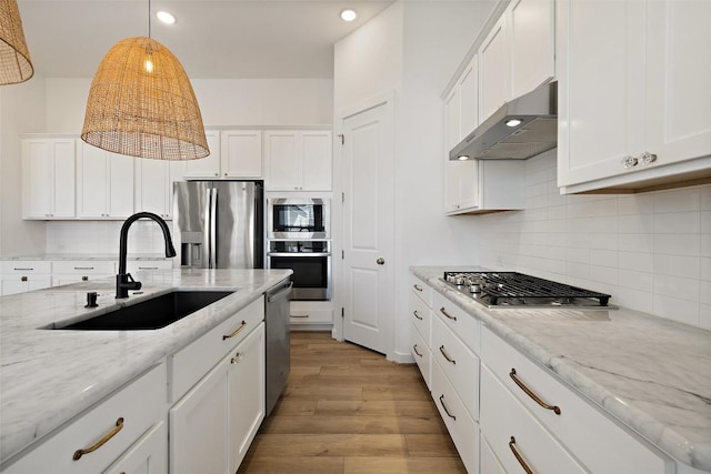 kitchen featuring a sink, white cabinetry, light wood-type flooring, exhaust hood, and stainless steel appliances