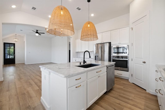 kitchen with stainless steel appliances, a ceiling fan, a sink, light wood-style floors, and vaulted ceiling