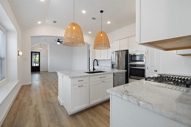 kitchen with visible vents, ceiling fan, appliances with stainless steel finishes, a sink, and vaulted ceiling