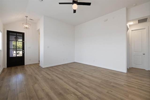 entryway with wood finished floors, ceiling fan with notable chandelier, lofted ceiling, baseboards, and visible vents