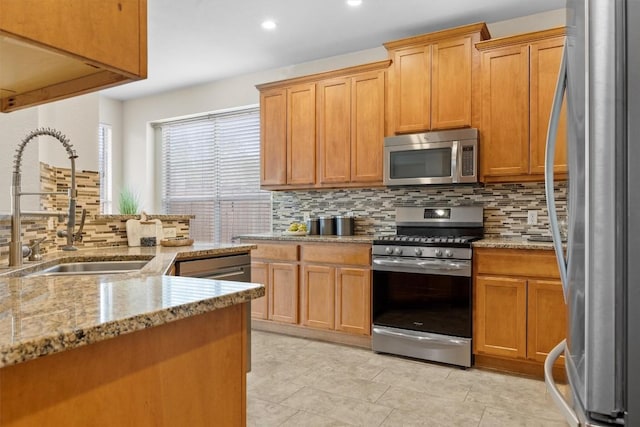 2701 Blackstone Cv, Round Rock, TX 78665 - kitchen with stainless steel appliances, a sink, decorative backsplash, light stone countertops, and recessed lighting
