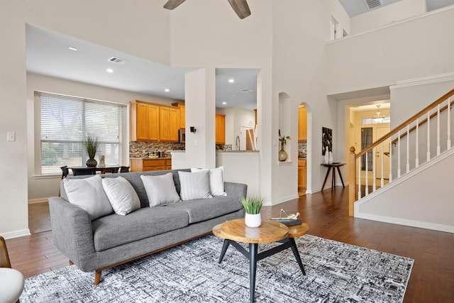 2701 Blackstone Cv, Round Rock, TX 78665 - living area featuring dark wood-style floors, stairway, baseboards, arched walkways, and a ceiling fan