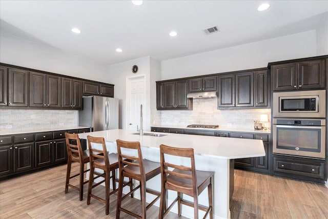 9003 Jodie Ln, Austin, TX 78748 - kitchen featuring appliances with stainless steel finishes, a sink, under cabinet range hood, light countertops, and backsplash