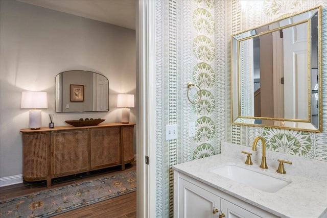 9003 Jodie Ln, Austin, TX 78748 - bathroom with wallpapered walls, vanity, wood finished floors, and baseboards