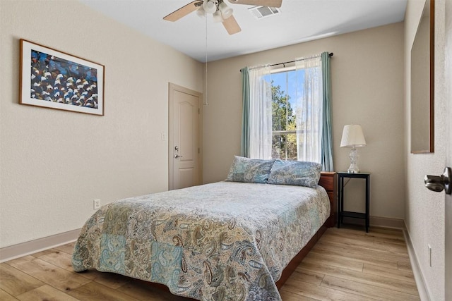 bedroom with baseboards, wood finished floors, and visible vents