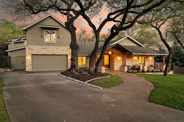 7603 Rustling Cv, Austin, TX 78731 - view of front of home featuring stone siding, driveway, an attached garage, and a porch