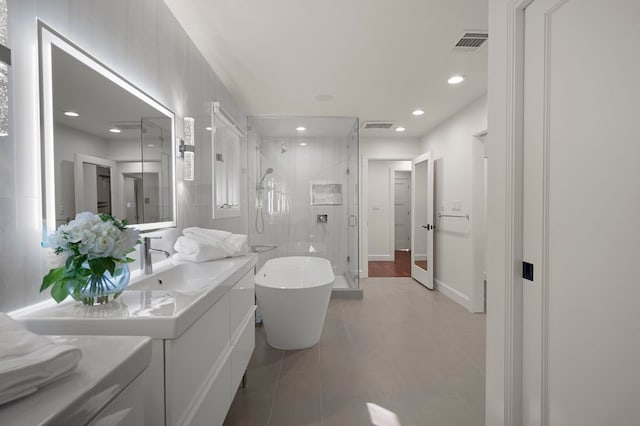7603 Rustling Cv, Austin, TX 78731 - bathroom with a stall shower, vanity, a soaking tub, recessed lighting, and tile patterned flooring