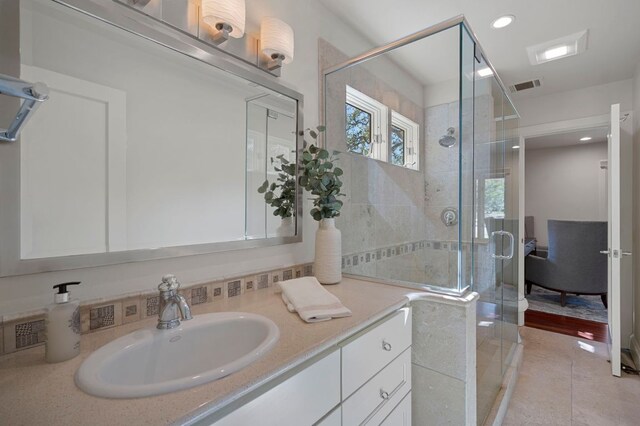 7603 Rustling Cv, Austin, TX 78731 - bathroom with vanity, a shower stall, recessed lighting, tile patterned floors, and decorative backsplash