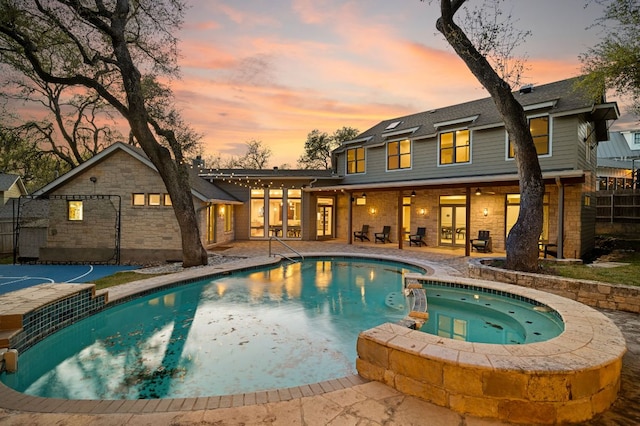 7603 Rustling Cv, Austin, TX 78731 - pool at dusk featuring french doors, a patio area, and a pool with connected hot tub