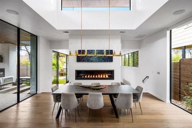 1411 Travis Heights Blvd, Austin, TX 78704 - dining room featuring hardwood / wood-style floors, a healthy amount of sunlight, a glass covered fireplace, and visible vents