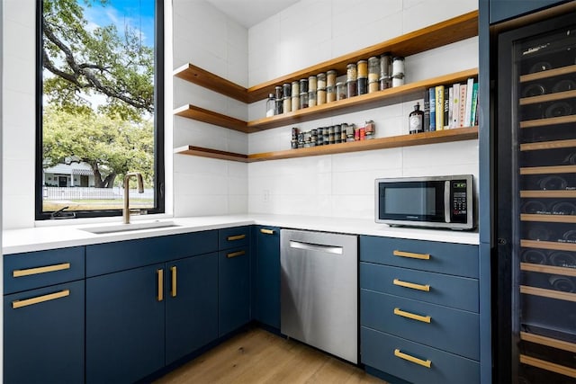 1411 Travis Heights Blvd, Austin, TX 78704 - bar featuring light wood-type flooring, tasteful backsplash, appliances with stainless steel finishes, and a sink