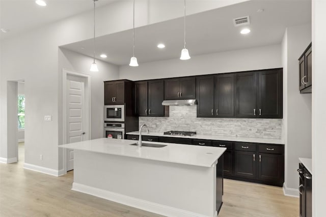 600 C-Bar Ranch Trl Unit 116, Cedar Park, TX 78613 - kitchen featuring appliances with stainless steel finishes, decorative backsplash, under cabinet range hood, light wood-type flooring, and recessed lighting