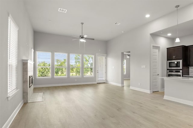 600 C-Bar Ranch Trl Unit 116, Cedar Park, TX 78613 - unfurnished living room with ceiling fan, light wood finished floors, a tiled fireplace, and recessed lighting