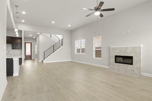 600 C-Bar Ranch Trl Unit 116, Cedar Park, TX 78613 - unfurnished living room with light wood-style flooring, a fireplace, recessed lighting, a ceiling fan, and stairway