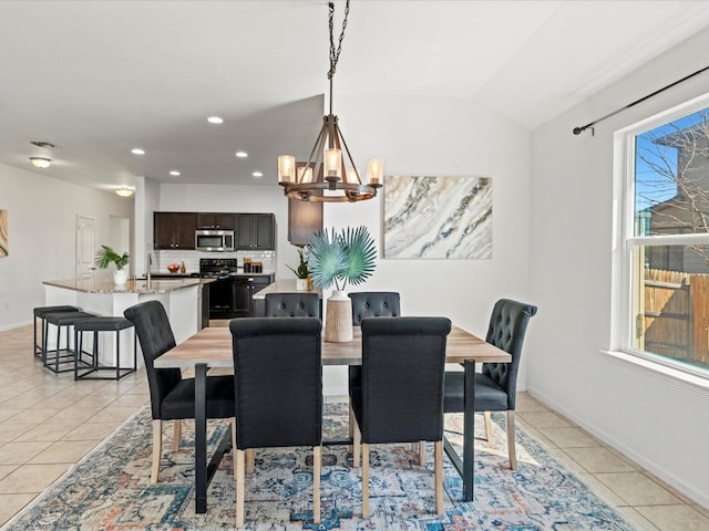 dining area with an inviting chandelier, recessed lighting, light tile patterned flooring, lofted ceiling, and baseboards
