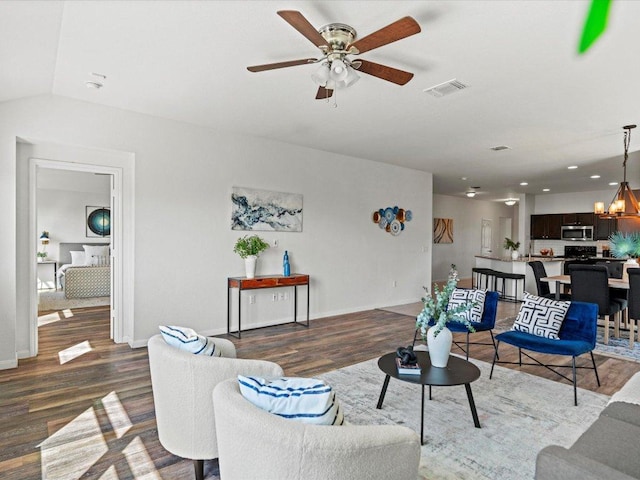 living area featuring visible vents, baseboards, recessed lighting, wood finished floors, and ceiling fan with notable chandelier