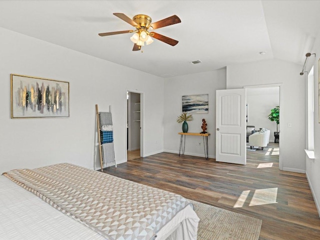 bedroom featuring a ceiling fan, visible vents, wood finished floors, lofted ceiling, and baseboards
