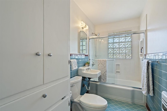 2708 W 49th St W, Austin, TX 78731 - full bathroom with tile walls, tile patterned floors, toilet, combined bath / shower with glass door, and a wainscoted wall