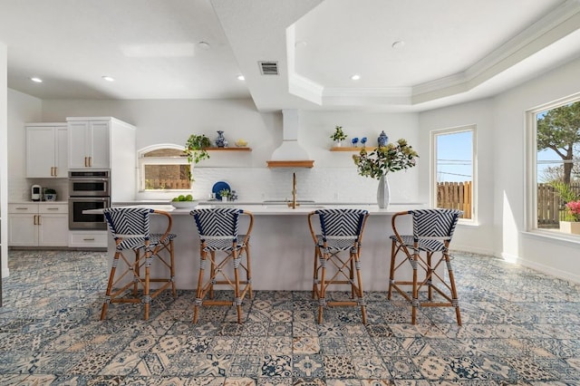 503 Eagle, Lakeway, TX 78734 - kitchen with double oven, open shelves, decorative backsplash, ornamental molding, and a breakfast bar