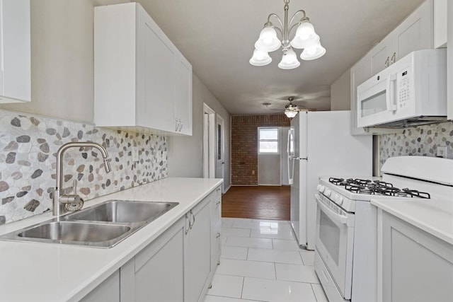 703 S 13th St, Copperas Cove, TX 76522 - kitchen with white appliances, light countertops, light tile patterned flooring, a chandelier, and tasteful backsplash