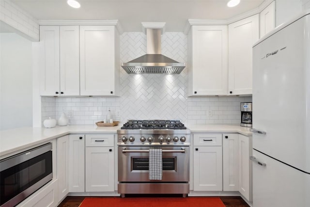 1213 S Church St, Georgetown, TX 78626 - kitchen with stainless steel appliances, wall chimney exhaust hood, backsplash, white cabinets, and recessed lighting