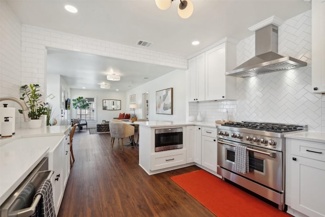 1213 S Church St, Georgetown, TX 78626 - kitchen featuring stainless steel appliances, wall chimney exhaust hood, dark wood-type flooring, light countertops, and white cabinetry