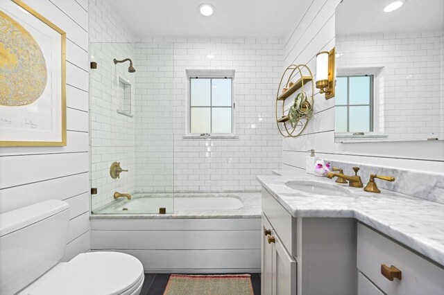 bathroom with toilet, vanity, shower / bath combination with glass door, and recessed lighting