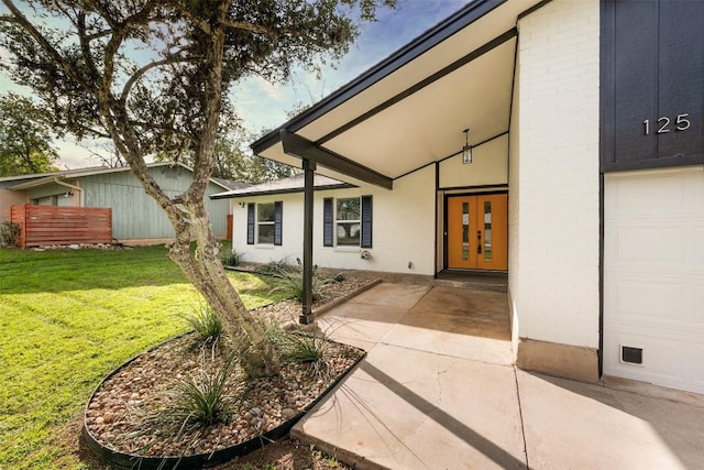 125 Chaparral St, San Marcos, TX 78666 - property entrance featuring a yard, a garage, and french doors