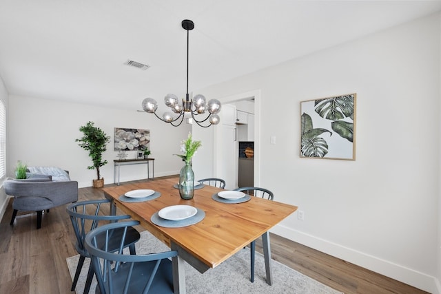 125 Chaparral St, San Marcos, TX 78666 - dining space with baseboards, wood finished floors, and a chandelier