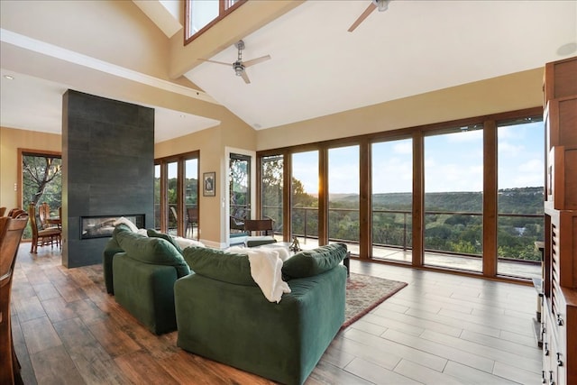 1002 Arroweye Trl, Austin, TX 78733 - living room featuring a ceiling fan, high vaulted ceiling, wood finished floors, and a fireplace