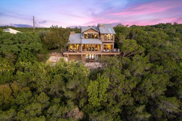1002 Arroweye Trl, Austin, TX 78733 - rear view of property with a balcony, a wooded view, and metal roof