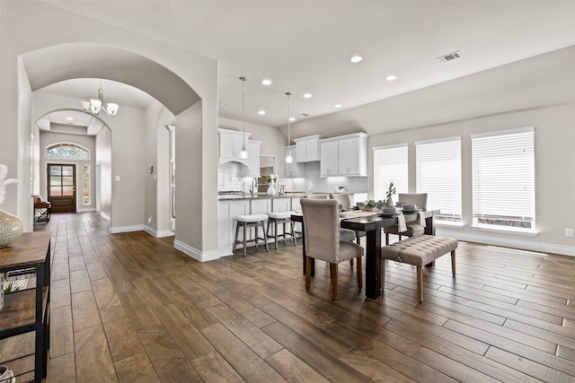 dining area with visible vents, baseboards, recessed lighting, arched walkways, and dark wood-type flooring