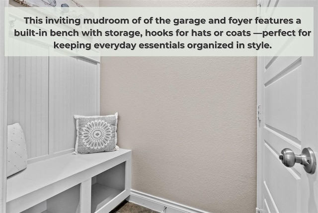 mudroom featuring baseboards and a textured wall