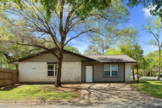 view of front of home featuring brick siding, fence, and a front yard