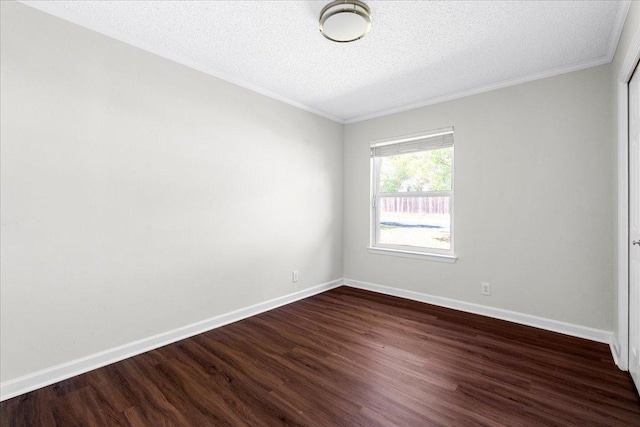 spare room with crown molding, dark wood-style flooring, a textured ceiling, and baseboards
