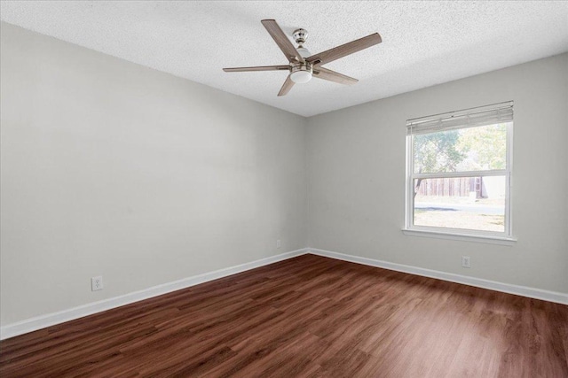unfurnished room featuring a textured ceiling, ceiling fan, baseboards, and dark wood-type flooring