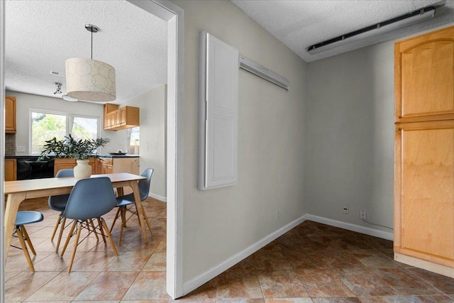 dining room with baseboards and a textured ceiling