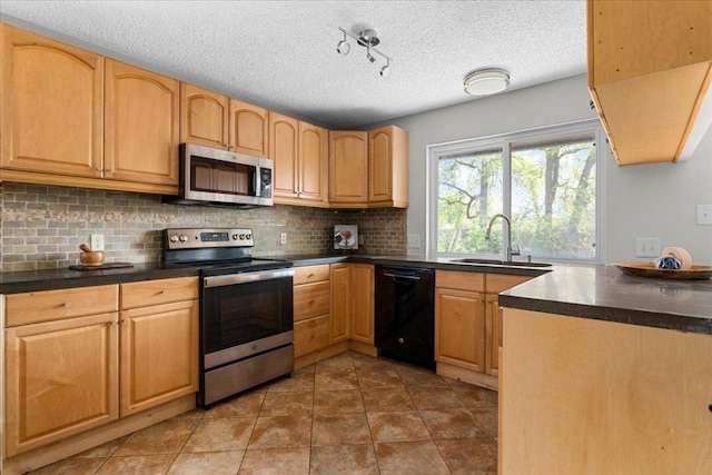 kitchen with dark countertops, appliances with stainless steel finishes, decorative backsplash, and a sink