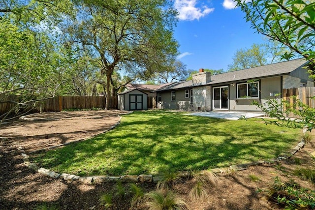 rear view of house featuring a storage shed, a fenced backyard, a chimney, a patio area, and an outdoor structure