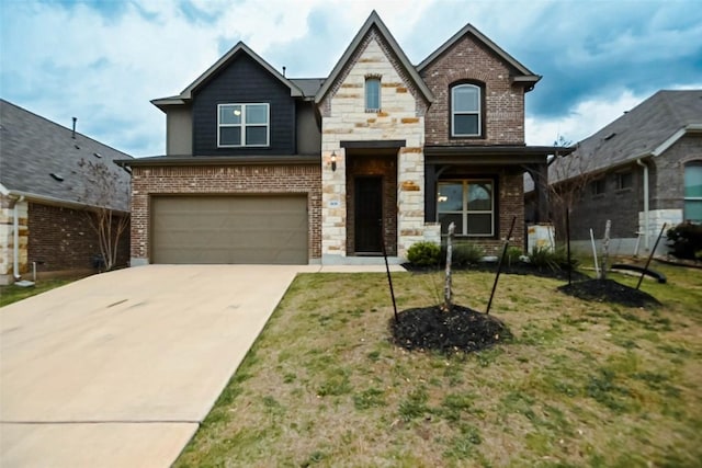 908 Leadtree Loop, Buda, TX 78610 - view of front of property featuring an attached garage, driveway, brick siding, a front yard, and stone siding