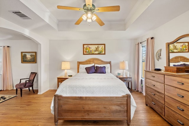 3919 Haleys Way, Round Rock, TX 78665 - bedroom with a raised ceiling, light wood-type flooring, arched walkways, ornamental molding, and ceiling fan