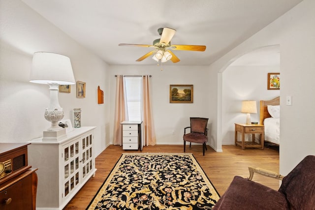 3919 Haleys Way, Round Rock, TX 78665 - living area with arched walkways, a ceiling fan, wood finished floors, and baseboards