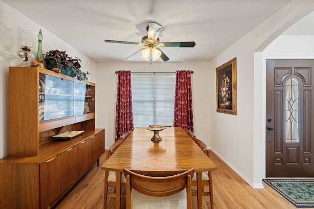 3919 Haleys Way, Round Rock, TX 78665 - dining area featuring light wood-style flooring, arched walkways, ceiling fan, and baseboards