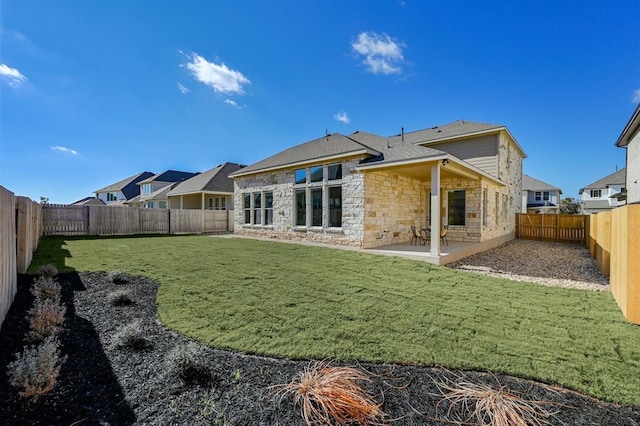 2316 Gold Dust Trl, Leander, TX 78641 - rear view of property with stone siding, a patio, and a fenced backyard