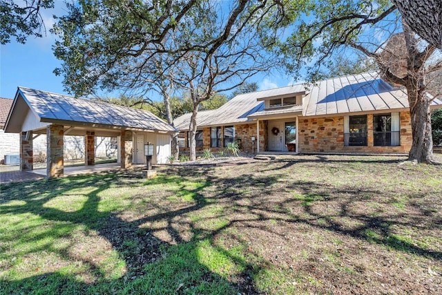 207 Lasso St, Horseshoe Bay, TX 78657 - rear view of property with stone siding, a standing seam roof, a metal roof, and a yard