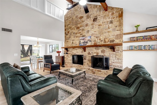 207 Lasso St, Horseshoe Bay, TX 78657 - living room with high vaulted ceiling, a ceiling fan, a chandelier, wood finished floors, and a stone fireplace
