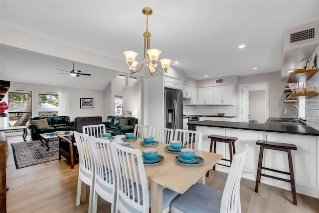 207 Lasso St, Horseshoe Bay, TX 78657 - dining room with a chandelier, ceiling fan, light wood-style floors, vaulted ceiling, and recessed lighting