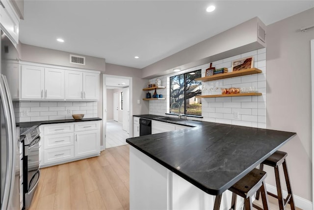 207 Lasso St, Horseshoe Bay, TX 78657 - kitchen with open shelves, decorative backsplash, white cabinetry, a peninsula, and range with electric cooktop