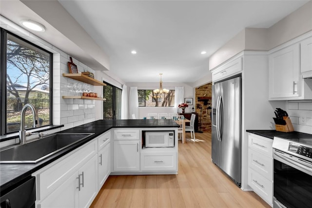 207 Lasso St, Horseshoe Bay, TX 78657 - kitchen featuring appliances with stainless steel finishes, a chandelier, white cabinets, dark countertops, and decorative backsplash